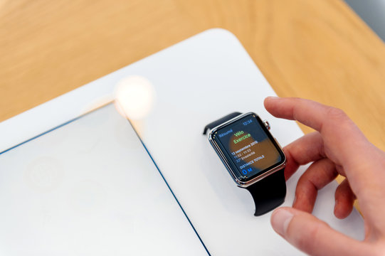 PARIS, FRANCE - SEP 12, 2016: Woman testing new Apple watch testing its functionalities before buying the latest smartwatch - testing new sport coach function bike velo