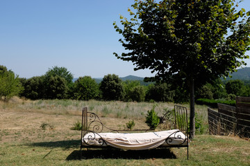 vintage bed to relax in sunny garden with countryside view
