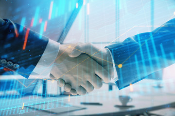 Obraz na płótnie Canvas Multi exposure of financial graph on office background with two businessmen handshake. Concept of success in business