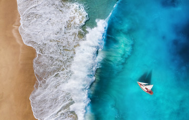 Fototapeta premium Yacht on the sea from top view. Turquoise water background from top view. Beach and waves. Summer seascape from air. Travel - image
