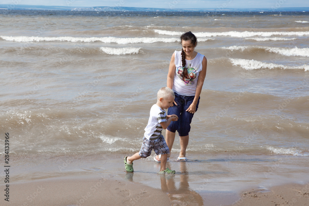 Wall mural the child walks with his mother on the beach