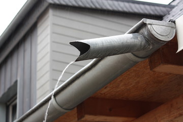 Ablaufkehle oder Schwanenhals an einer Dachrinne bei Regen an einem Carport in Heintrop...