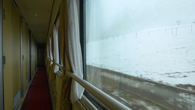 SLOW MOTION, CLOSE UP: Unrecognizable tourist taking photos of snowy Tibet during train ride. Curious passenger observing and taking pictures of the snow covered landscape while crossing Himalaya.