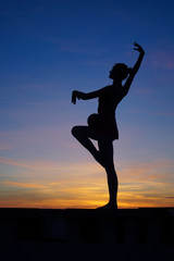 Fototapeta premium dancer in the dance does the splits in the air against the sunset