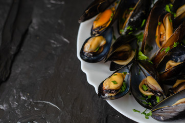Freshly cooked mussels with parsley. Healthy food concept. Selective focus, copy space