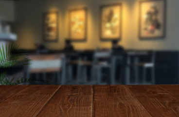 Wooden perspective table in front of abstract blurred background of cafe or restaurant 