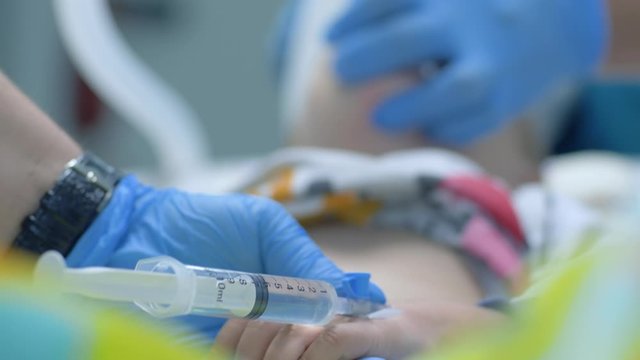 an injection of anesthesia, doctor prescribed a dental treatment for patient child under general anesthesia in modern stomatological clinic and pricked an injection with medical medic