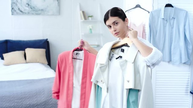 woman in bathrobe choosing clothes to wear in bedroom