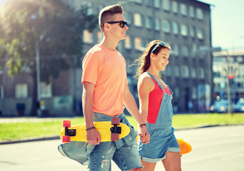 summer holidays, extreme sport and people concept - happy teenage couple with short modern cruiser...