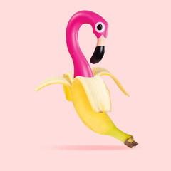 An alternative view of usual fruits. Banana as a pink flamingo on coral background. Negative space...