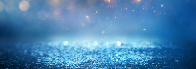 blackground of abstract glitter lights. blue, gold and black. de focused