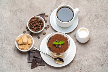 Classic tiramisu dessert in a glass, coffee, chocolate, cream and sugar on concrete background