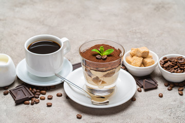 Classic tiramisu dessert in a glass, coffee, chocolate, cream and sugar on concrete background