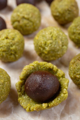 Chocolate praline balls wrapped in marzipan shell. Step of cooking marzipan raw-vegan candies, close-up.