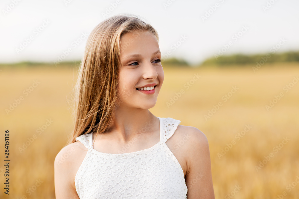 Wall mural nature and people concept - smiling young girl on cereal field in summer