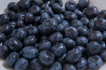  Clean freshly picked blueberries on white plate - close up studio shot. ( Ingredients:  Antioxidants , Vitamin C, Antioxidant)