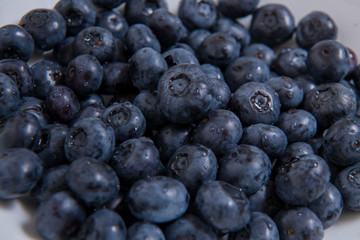  Clean freshly picked blueberries on white plate - close up studio shot. ( Ingredients:  Antioxidants , Vitamin C, Antioxidant)