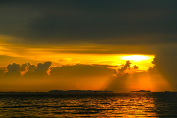 colorful of sunset ray on cloud sky fishing boat on island and sea