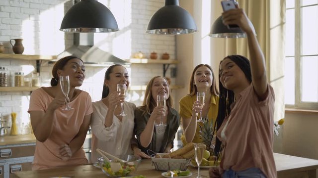 modern technologies. a company of happy friends is chatting with friends. Women-men say hello to the mobile phone screen and drink champagne 4K