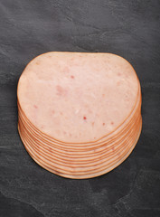 Smoked slices ham on black stone serving plate