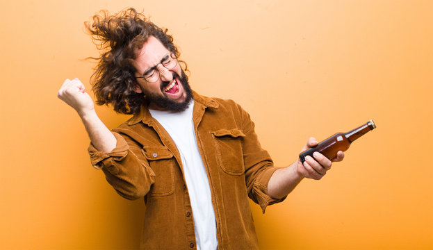 young man with crazy hair in motion drinking a beer