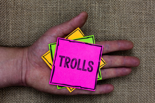 Text sign showing Trolls. Conceptual photo Online troublemakers posting provocative inflammatory messages Holding small pitches art papers thoughts ideas memories mat black shadow
