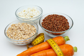 raw chicken breast, cereals, brown rice, measuring tape, farm cottage cheese carrot close up on white background protein healthy diet fat free concept eco product sports nutrition