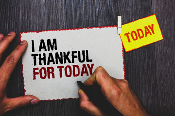 Handwriting text writing I Am Thankful For Today. Concept meaning Grateful about living one more day Philosophy Hand grip black marker writing text paperclip stick written page woody deck