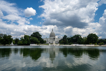 Fototapeta na wymiar Wide angle view of the United States Capitol Building in Washington DC on a partly cloudy summer day, on the reflecting pool