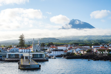 The church and city of Madalena against the Pico Volcano Mountain and blue sky, Pico Island, Azores...