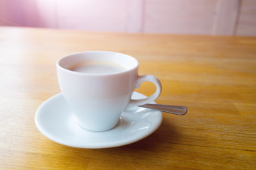 Americano coffee in a white cup on a wooden table. Cozy minimalistic still life. Place for text.