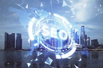 SEO hologram on city view with skyscrapers background double exposure. Search optimization concept.