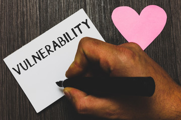 Handwriting text writing Vulnerability. Concept meaning State of being exposed to the possibility of being attacked Man hand holding marker white paper romantic feelings Wooden background