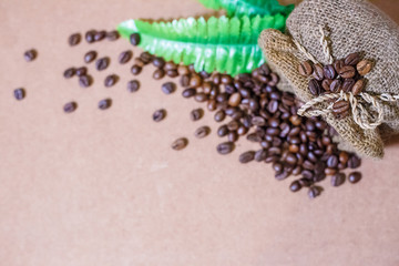 Close up coffee beans and Blur coffee beans in coffee burlap bag on old wooden background. Copy space for text.