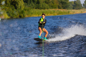 Young Sexy girl Catch waves on wakeboard when boat pulls a wakeboard 