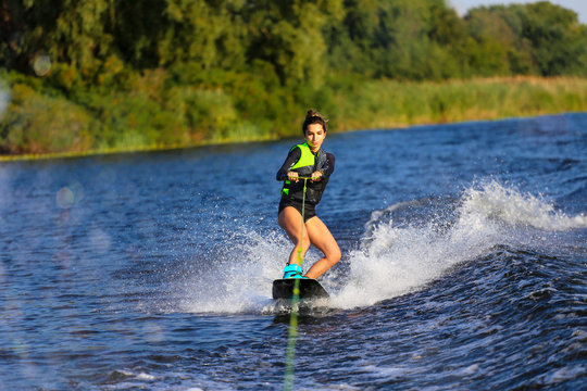 Young Sexy girl Catch waves on wakeboard when boat pulls a wakeboard 