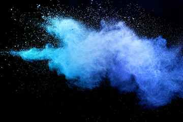 Blue powder explosion on black background. Colored cloud. Colorful dust explode. Paint Holi.