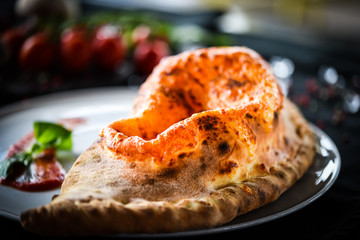 tasty italian calzone pizza with fresh ingredients and vegetables