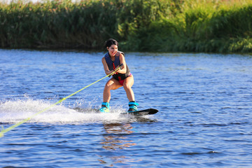 Happy girl riding on wakeboard at sunny day , smiling and happy 
