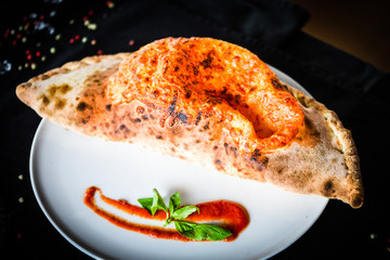 tasty italian calzone pizza with fresh ingredients and vegetables