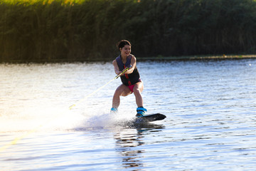 Happy girl riding on wakeboard at sunny day , smiling and happy 