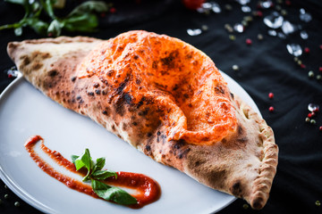 tasty italian calzone pizza with fresh ingredients and vegetables