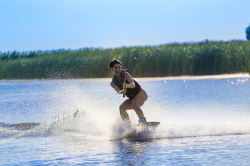 Happy girl riding on wakeboard at sunny day , smiling and happy 