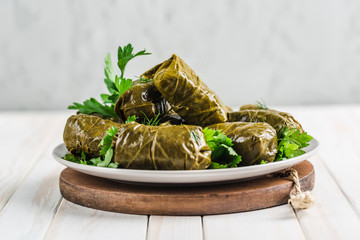 Delicious stuffed grape leaves (traditional doom Mediterranean cuisine Dolma) on a black plate with...