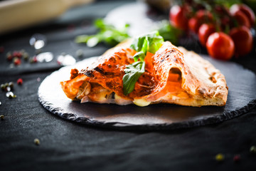 tasty italian calzone pizza with fresh ingredients and vegetables