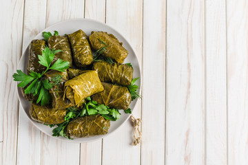 Delicious stuffed grape leaves (traditional doom Mediterranean cuisine Dolma) on a black plate with...
