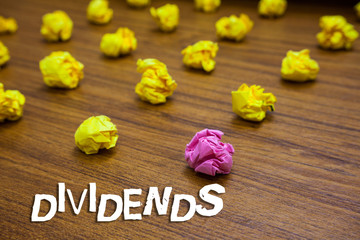 Conceptual hand writing showing Dividends. Business photo showcasing sum of money paid regularly by company to shareholders out profits Lots crumpled papers mistakes not satisfied wooden floor