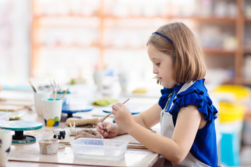 Child at pottery wheel. Kids arts and crafts class