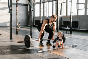 Adult man and little boy doing deadlift