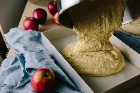 Cake batter being poured into a traybake pan